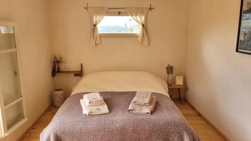 een slaapkamer met een bed met twee handdoeken erop bij La Luna in Clil in Clil