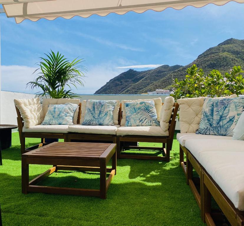 un patio con sofás y una mesa de centro sobre la hierba en Quinta Los Tizones, en Santa Cruz de Tenerife