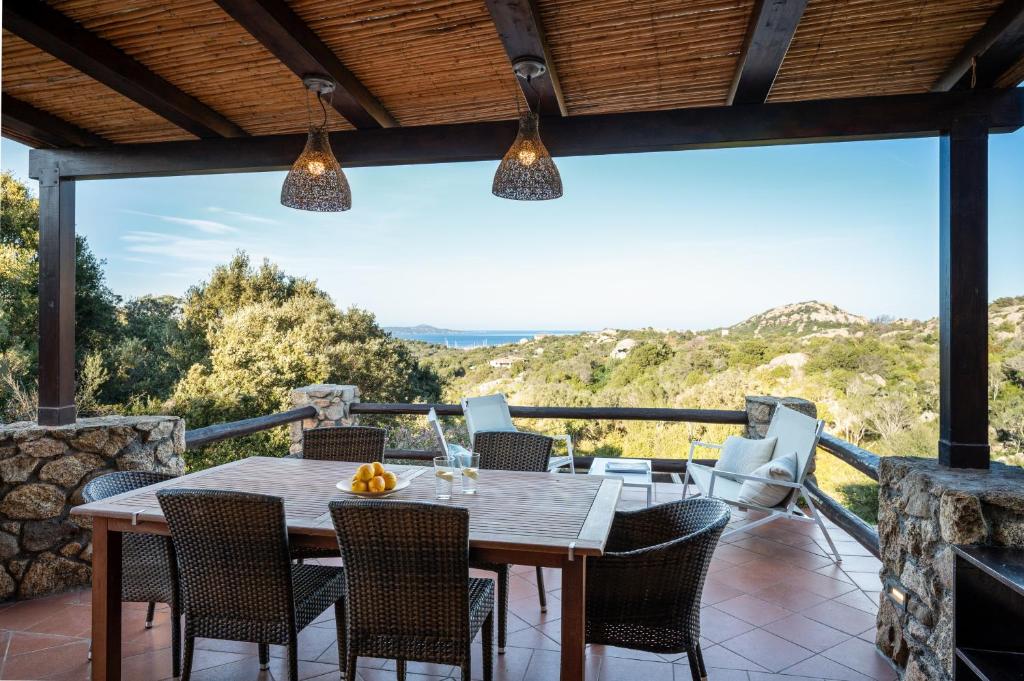 a dining room with a table and chairs on a patio at I Lecci 1 by Klodge in Olbia