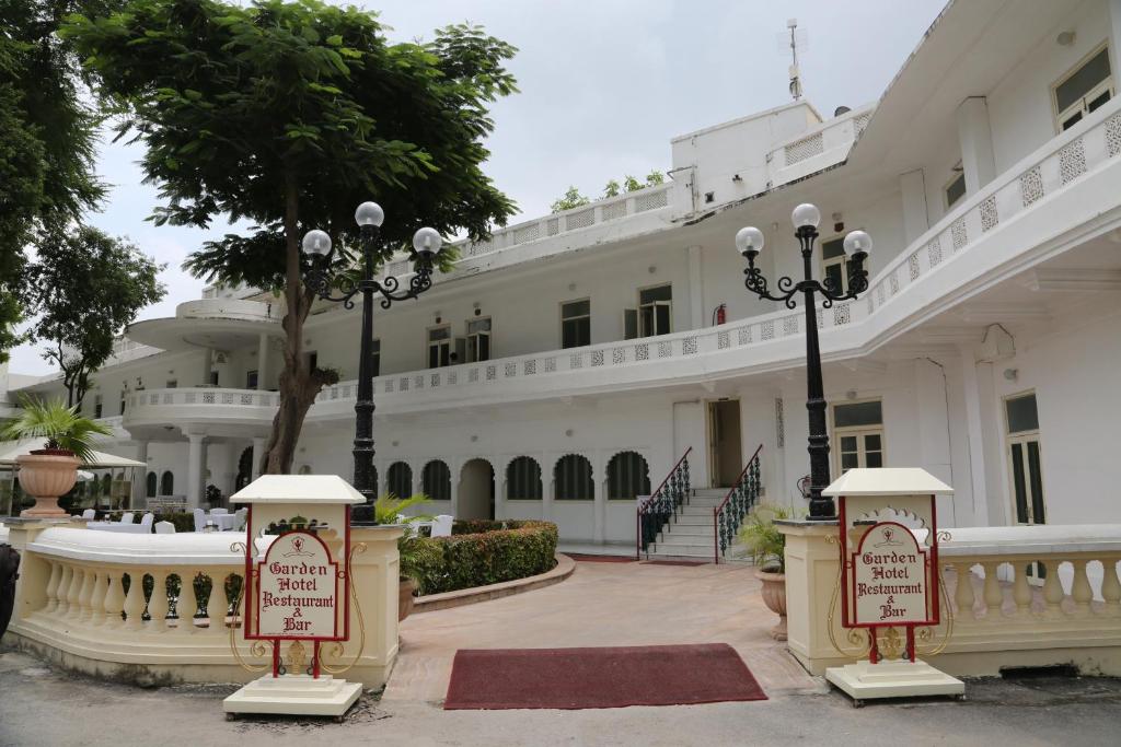 un gran edificio blanco con luces de la calle delante de él en Garden Hotel by HRH Group of Hotels, en Udaipur