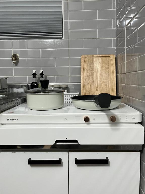 a kitchen with two pans on top of a stove at Nroo Stay in Seoul