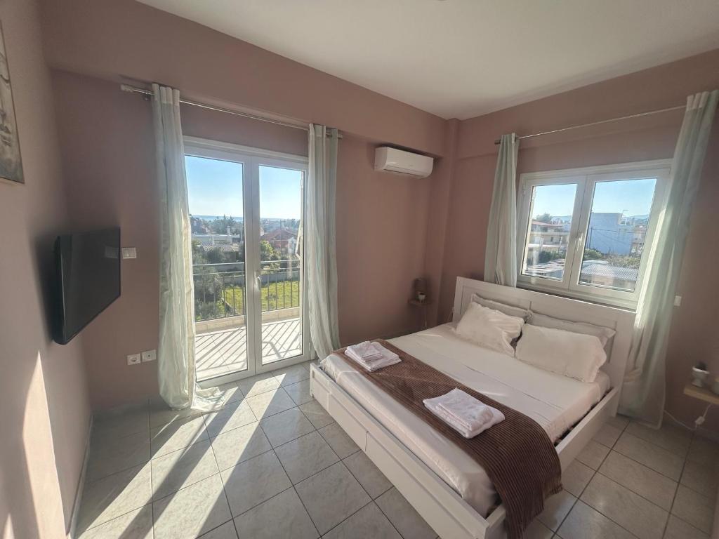 een slaapkamer met een bed en een groot raam bij AKTIS apartment near airport in Artemida