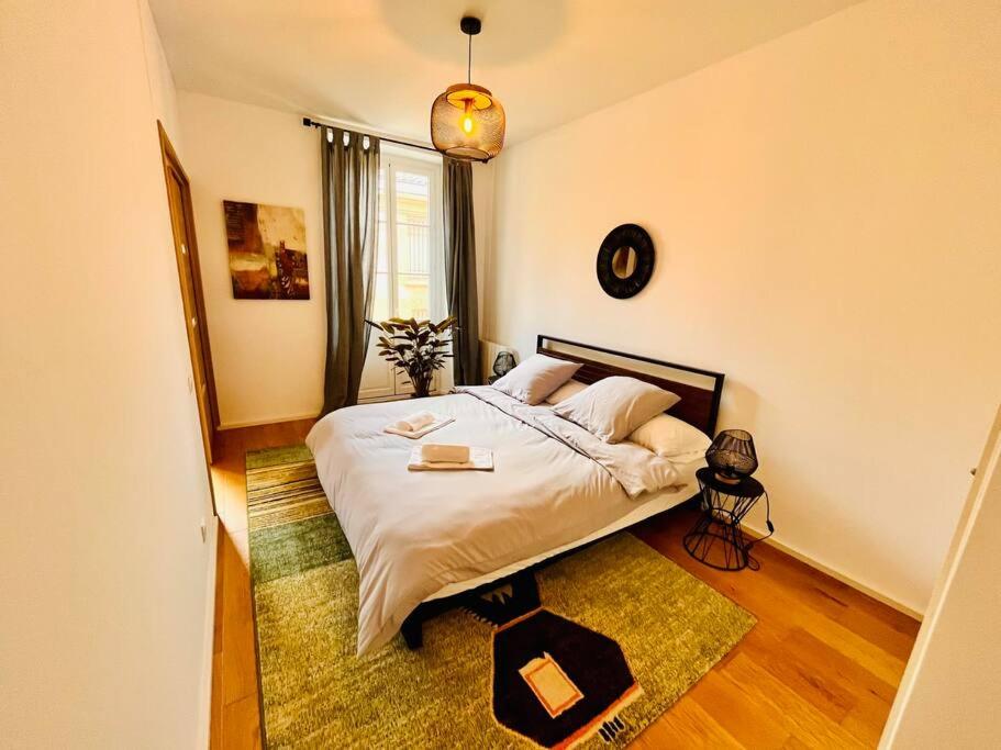 een slaapkamer met een bed en een groot raam bij Beautiful Apartment in City Center in Bordeaux