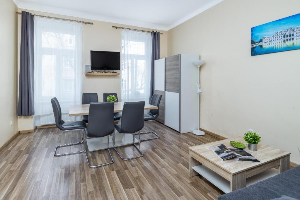 ein Wohnzimmer mit einem Esstisch und Stühlen in der Unterkunft Apartment Puchsbaumgasse in Wien