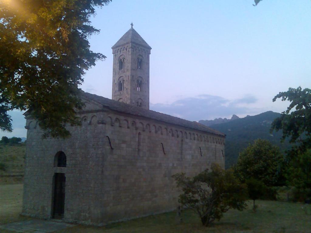 een oud stenen gebouw met een klokkentoren erop bij A Casa Carbinesa in Carbini