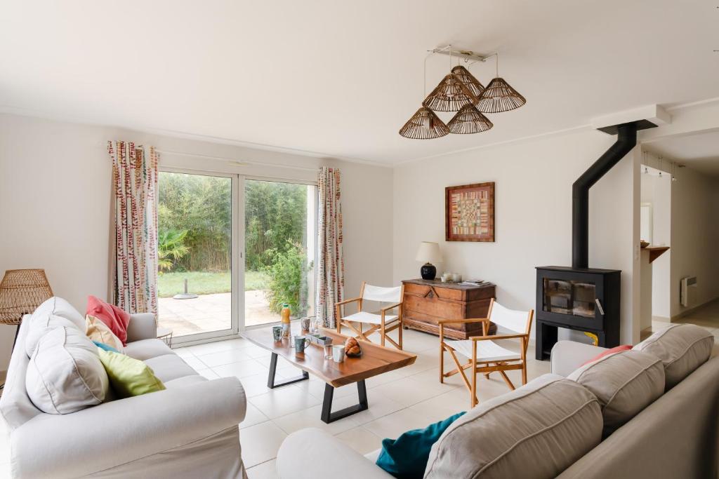 Elle comprend un salon doté d'un mobilier blanc et d'une cheminée. dans l'établissement La Camillette - 5 chambres à 10min de la plage, à Pléneuf-Val-André