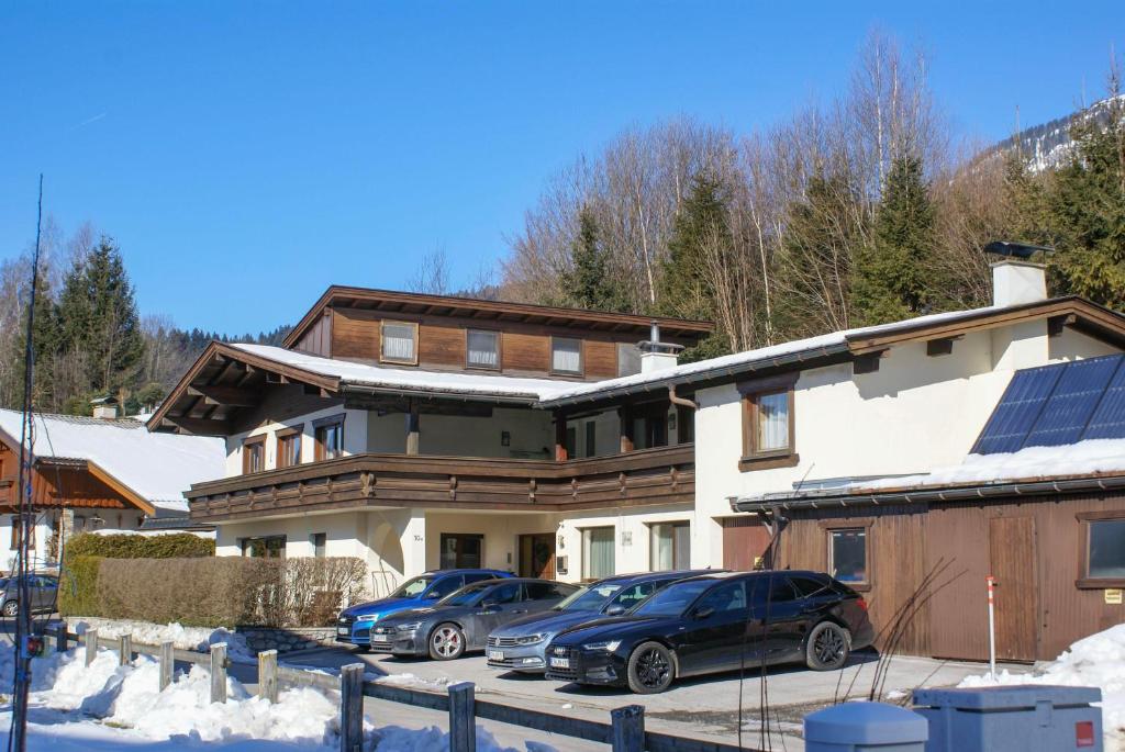 a house with two cars parked in a parking lot at Gästehaus Kracher in Fieberbrunn