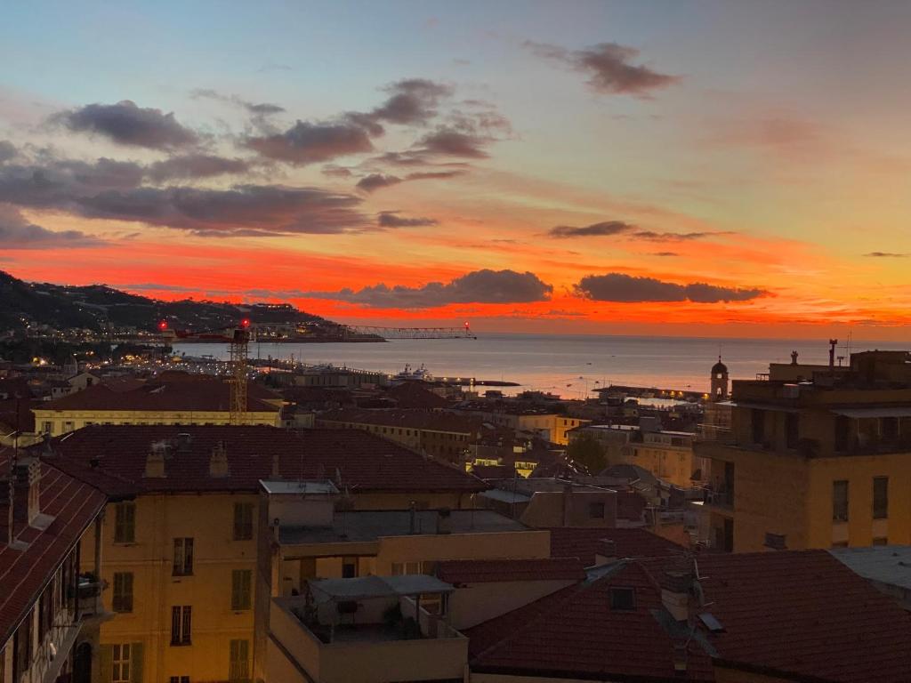 a sunset over a city with buildings and the ocean at La Casa di Gill in Sanremo