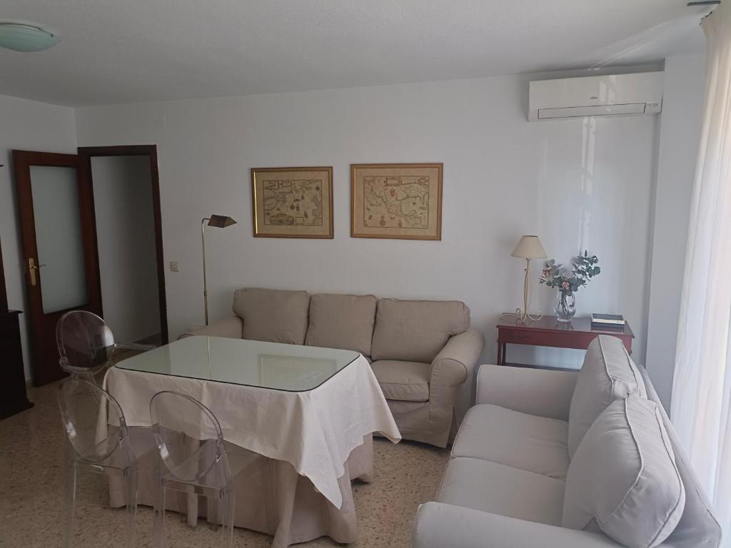 een woonkamer met een bank en een tafel bij Piso para 6 junto al acueducto. A pasos del centro in Sevilla