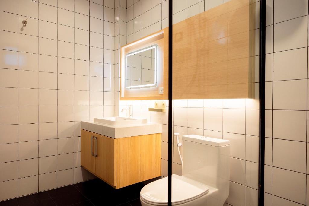 a bathroom with a toilet and a sink at Karpenter Lampang in Lampang