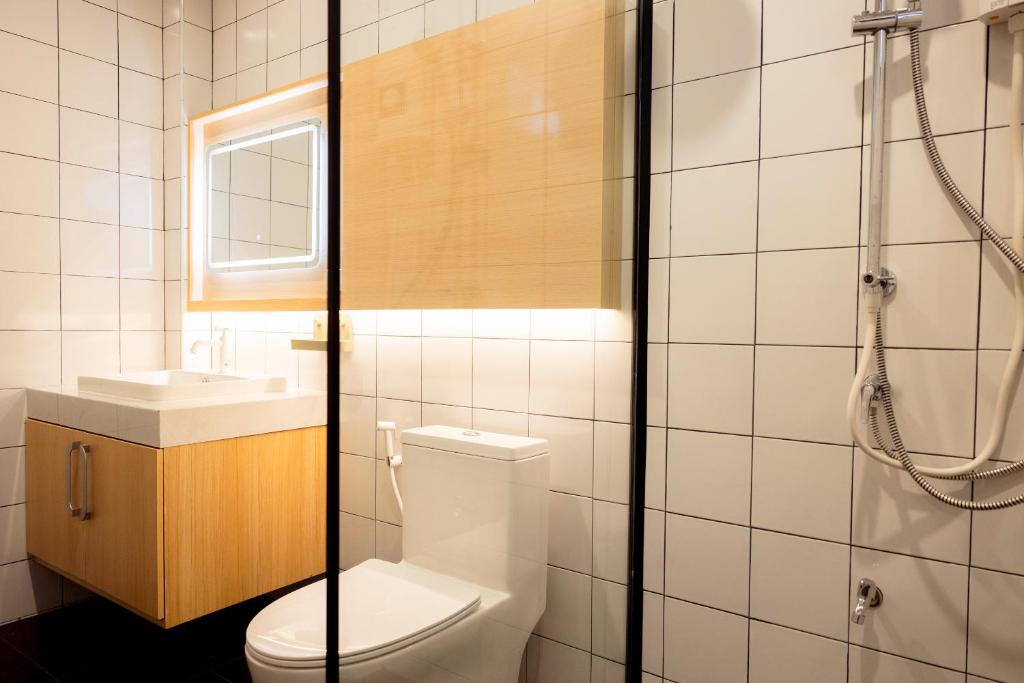 a bathroom with a toilet and a sink and a shower at Karpenter Lampang in Lampang