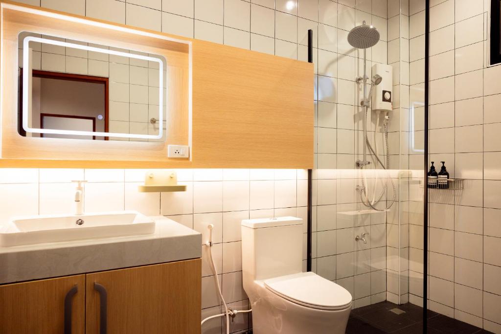 a bathroom with a toilet and a sink and a shower at Karpenter Lampang in Lampang