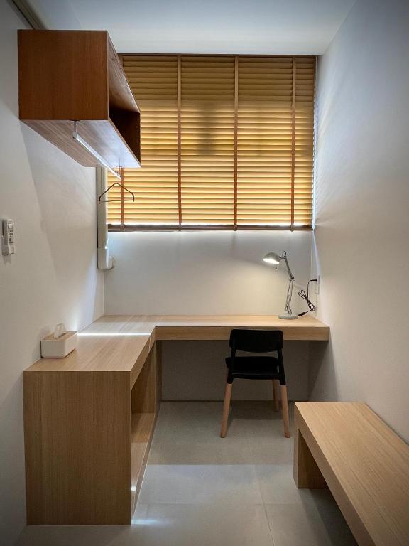 a home office with a desk and a window at Karpenter Lampang in Lampang