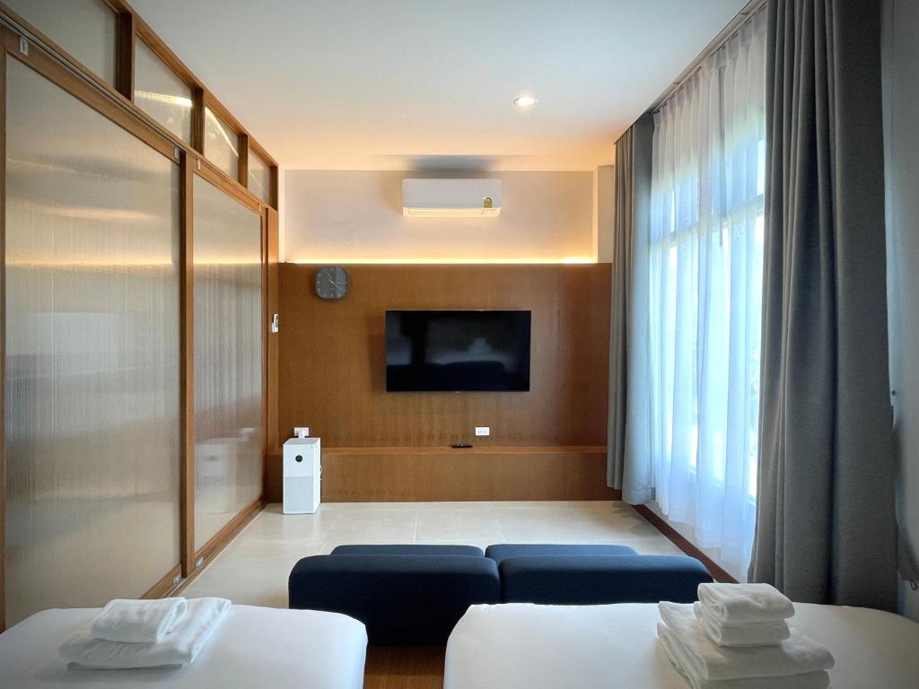 a hotel room with two beds and a flat screen tv at Karpenter Lampang in Lampang