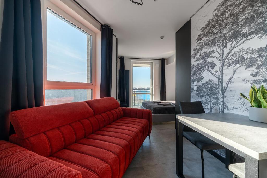 - un salon avec un canapé rouge et une table dans l'établissement Nowe Apartamenty Warszawa Wiktoryn TV Smart WI-FI, à Varsovie