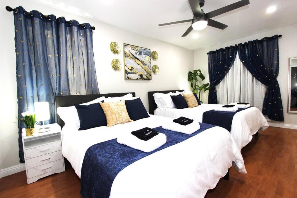 two beds in a bedroom with blue and white at NEW! 2-Bedroom Fontana Guest House near Speedway in Fontana