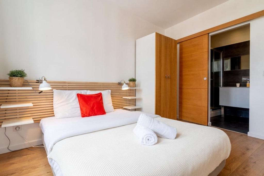 里爾的住宿－Vieux Lille appartement 1 chambre，卧室配有带红色枕头的大型白色床