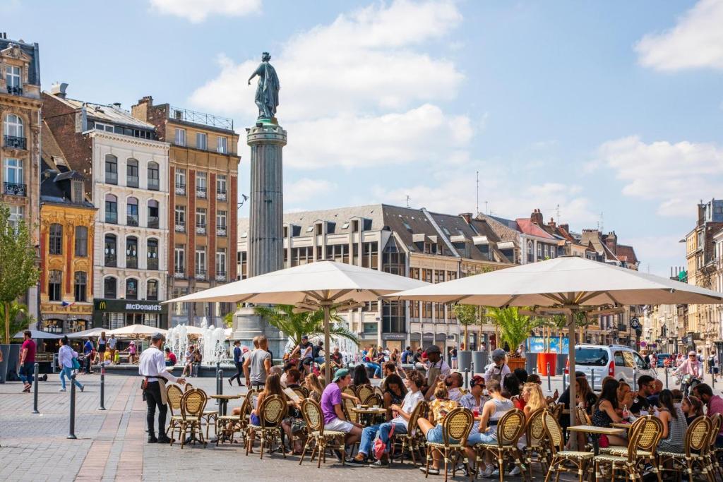 a group of people sitting at tables in a city at Vieux Lille appartement 1 chambre in Lille