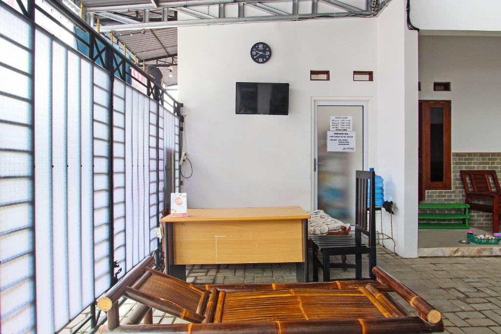 - biurko i krzesła w pokoju z oknami w obiekcie OYO 91817 Hotel Grand New Si Jago w mieście Kebumen