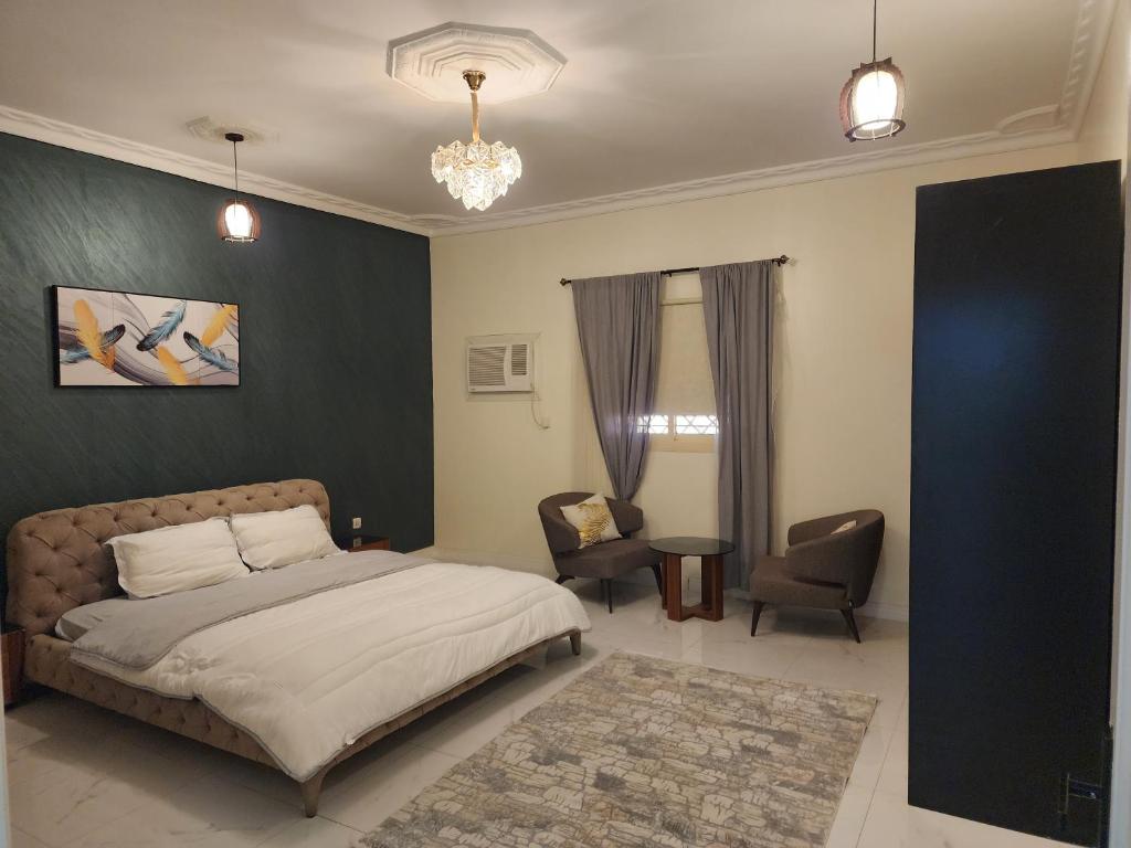 a bedroom with a bed and a chair at شقة عائلية فخمة in Al Madinah