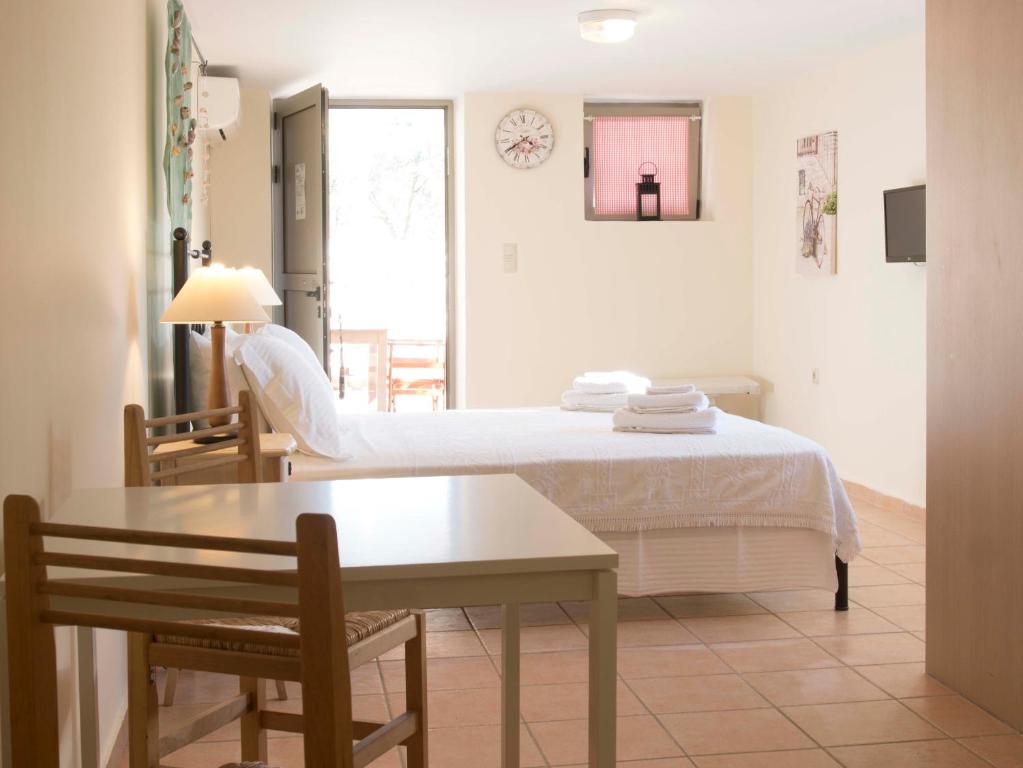 een slaapkamer met een bed en een tafel en een kamer bij Poliana Estate Studios in Kotrónion