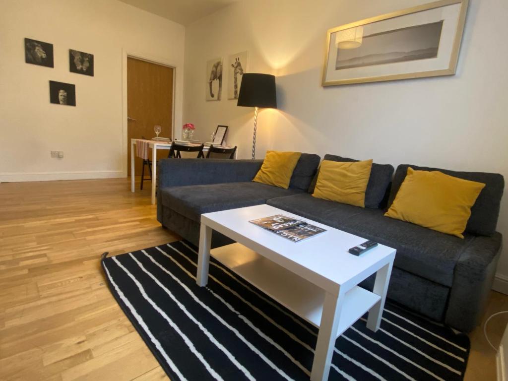 a living room with a blue couch and a table at Midland Apartments- one bedroom in Leicester