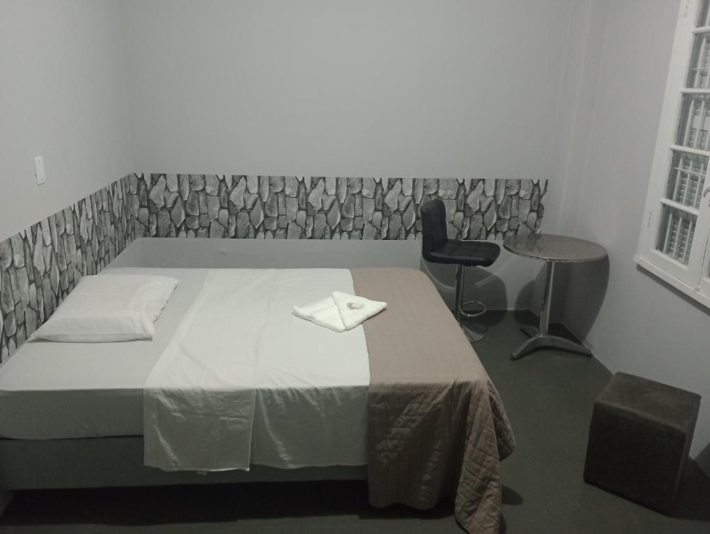 - une chambre avec un lit, une table et une chaise dans l'établissement Hotel Rest, à Porto Alegre