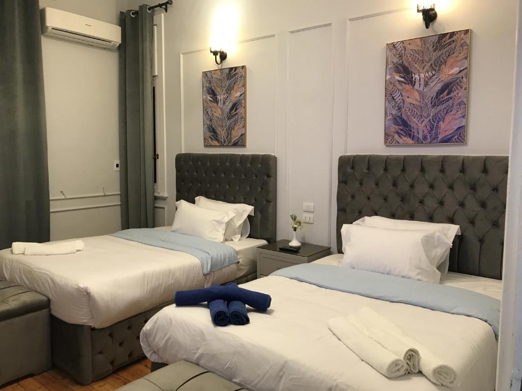 um quarto de hotel com duas camas com toalhas em Yacoubian Suites no Cairo