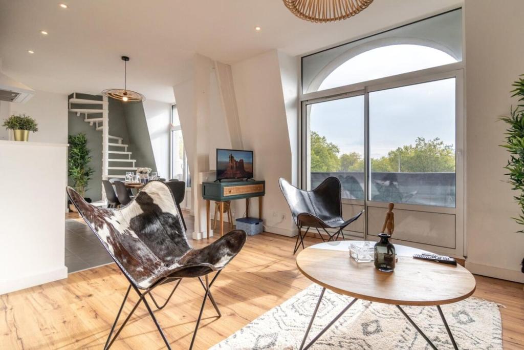 a living room with chairs and a table and a piano at Marcq en Baroeul - Superb apartment + parking in Marcq-en-Baroeul