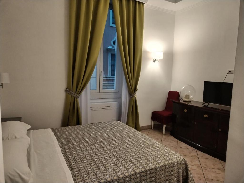 um quarto com uma cama, uma janela e uma cadeira em B&B L'Esquilina em Roma