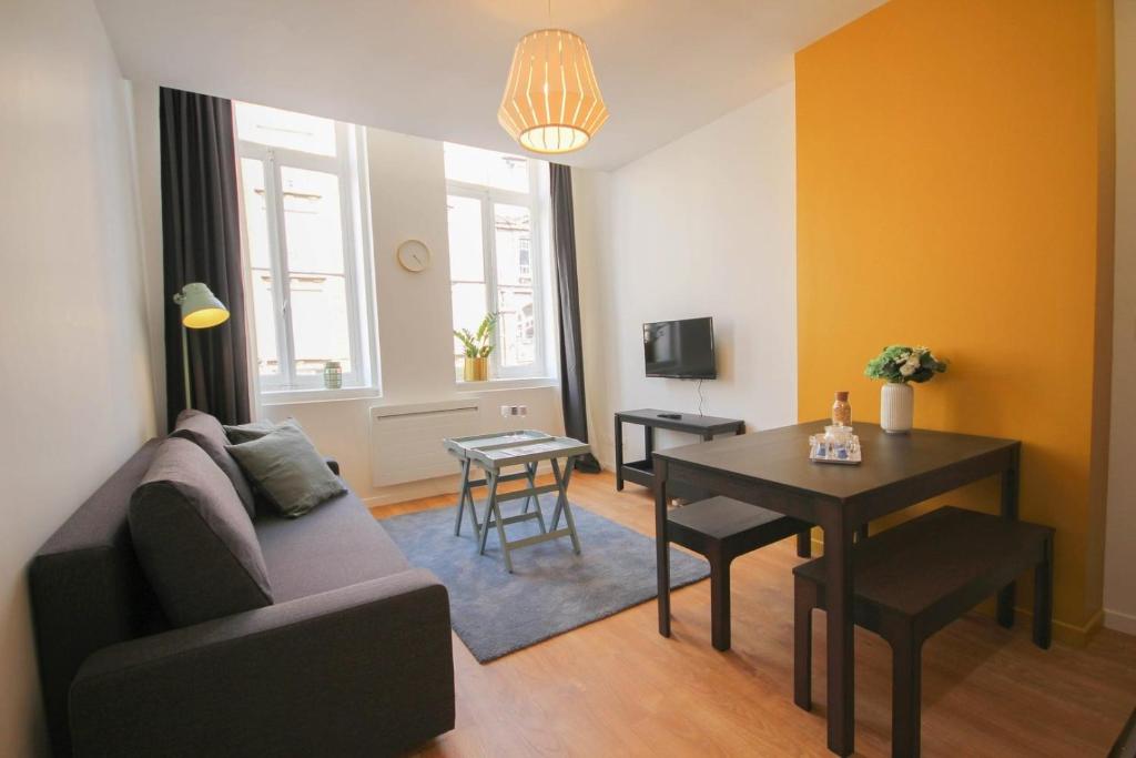 sala de estar con sofá y mesa en Superb apartment near the Grand Place! en Lille