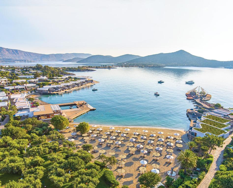 eine Luftansicht auf einen Strand mit Sonnenschirmen in der Unterkunft Elounda Beach Hotel & Villas, a Member of the Leading Hotels of the World in Elounda