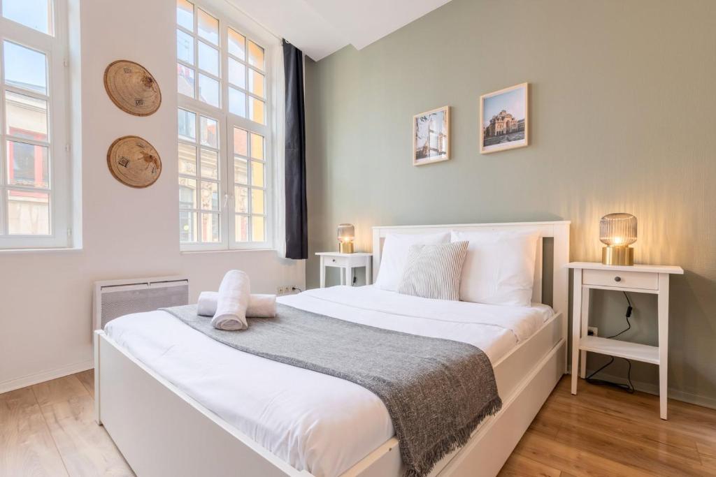 een slaapkamer met een groot wit bed en 2 ramen bij Lille Grand Place - Exceptional location ! in Lille