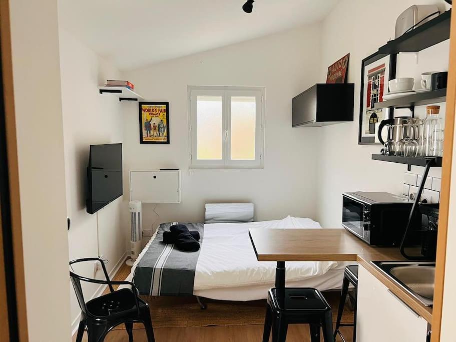 une chambre avec un lit, une table et des chaises dans l'établissement La Petite Grange - 5 mn gare SNCF - Wifi & Netflix, à Niort