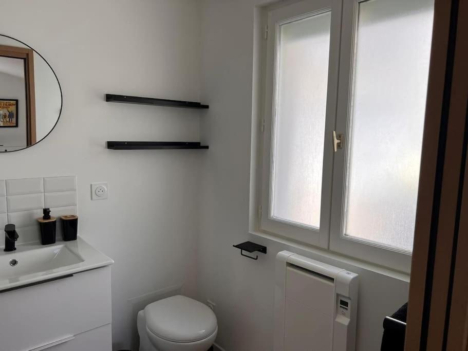 a white bathroom with a toilet and a window at La Petite Grange - 5 mn gare SNCF - Wifi &amp; Netflix in Niort
