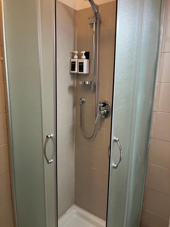 baño con ducha y puerta de cristal en Soggiorno dell Agnolo, en Florencia