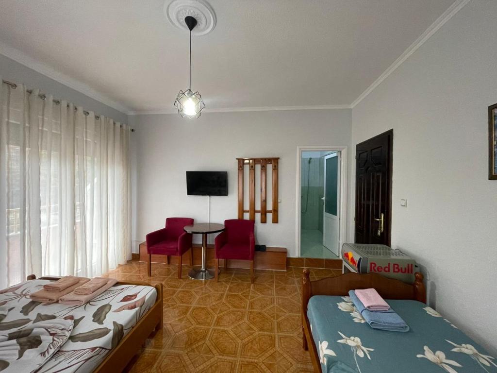 a bedroom with a bed and a table and chairs at Eiffel's Guest House in Pogradec