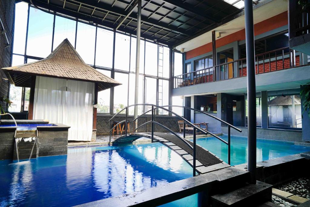 Une grande piscine avec un escalier se trouve dans un bâtiment. dans l'établissement Pondok Sukamulus by GroRental, à Cihanjuang 1