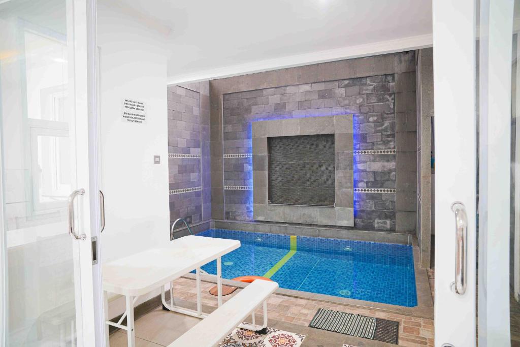 una piscina en una habitación con una mesa y un banco en Schones Haus Private Pool & Netflix by GroRental, en Bandung