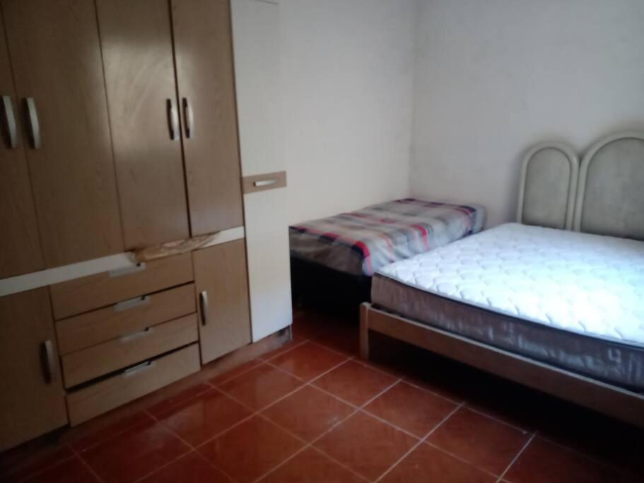 een kleine kamer met 2 bedden en een kast bij Casa de campo agradável com piscina aquecida in Juatuba