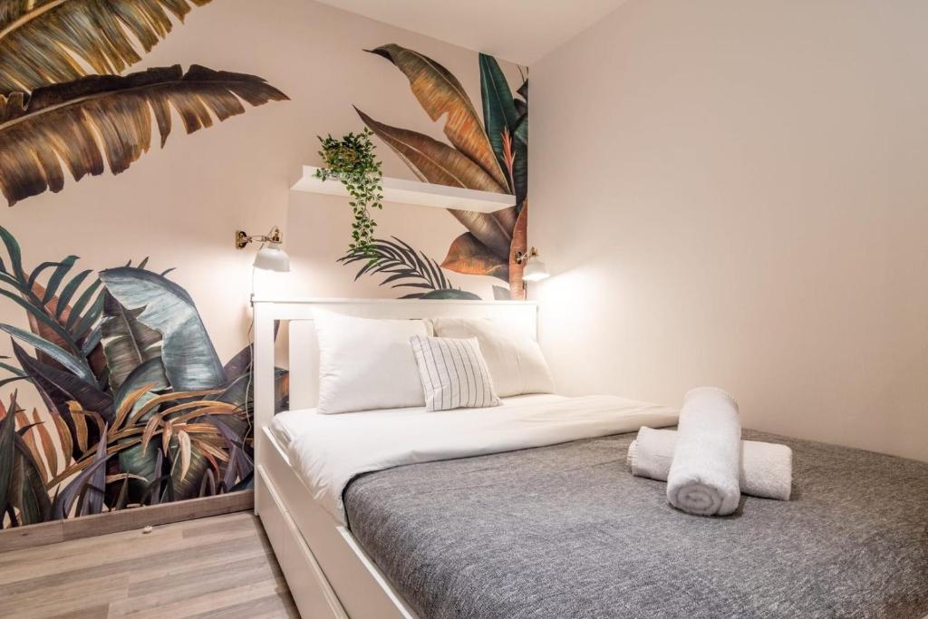 ein Schlafzimmer mit einem Bett mit Pflanzen an der Wand in der Unterkunft Lille Grand-place : Functional and quiet studio ! in Lille