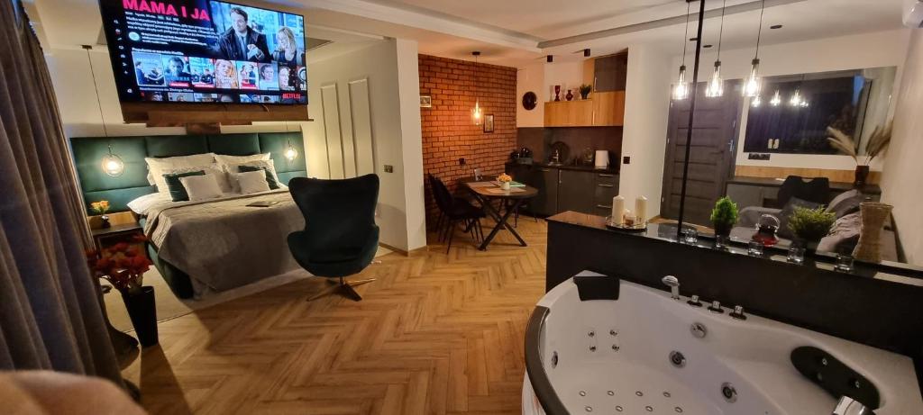 ein Schlafzimmer mit einem Bett und einer Badewanne sowie einem TV in der Unterkunft Happy time together apartament z Jacuzzi in Wojkowice