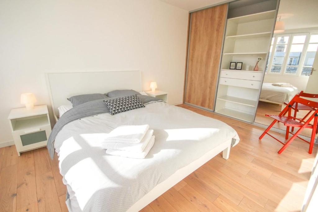 1 dormitorio con 1 cama blanca grande y espejo en Lille République-Nice and bright flat with Balcony, en Lille