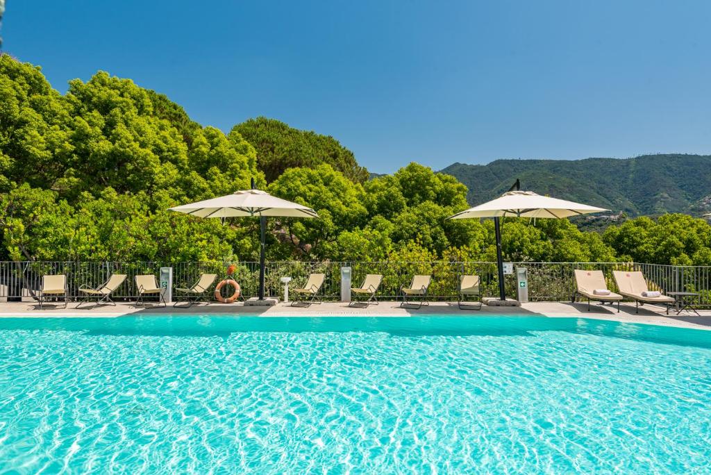 ein Swimmingpool mit Stühlen und Sonnenschirmen in der Unterkunft Park Hotel Argento in Levanto