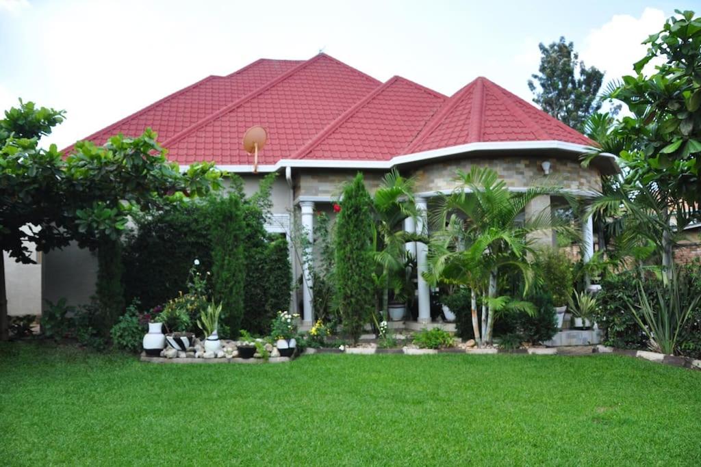 una casa con techo rojo y patio en VILLA MODERNE CHEZ YVONNE en Kigali