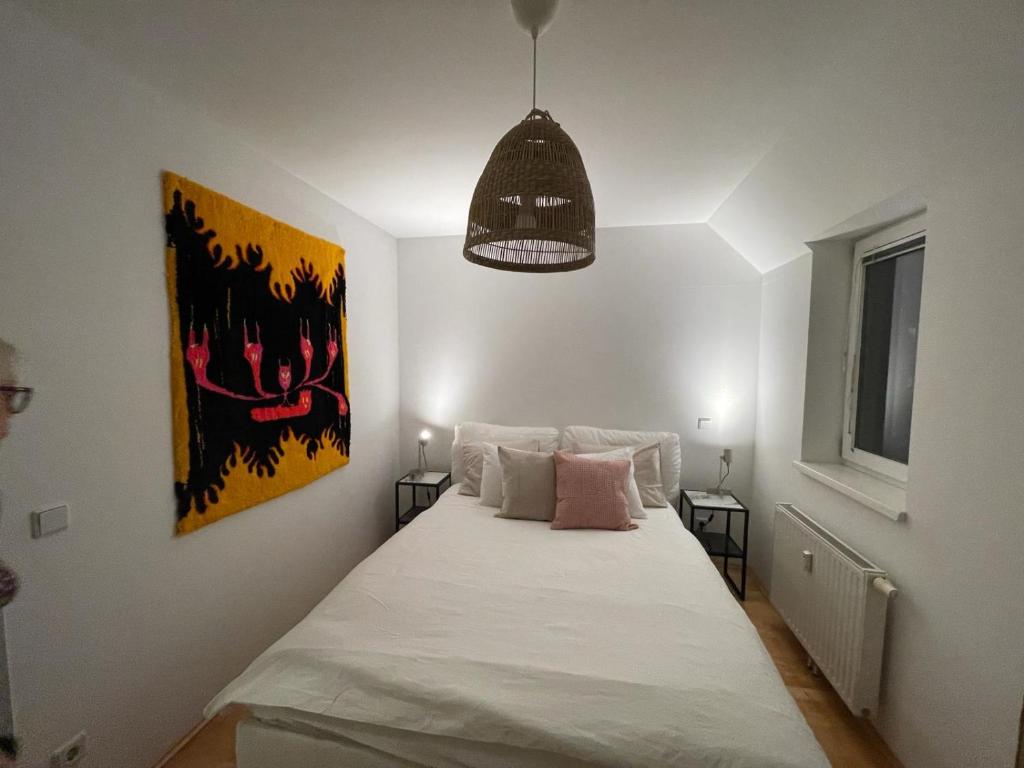ein Schlafzimmer mit einem großen Bett mit weißer Bettwäsche und rosa Kissen in der Unterkunft Traumwohnung mit Balkon im 17 Bezirk in Wien