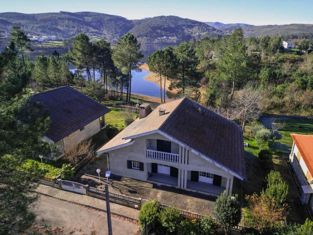 una vista aérea de una casa blanca con un lago en Casa da barragem - Ninho das Águias en Venda Nova