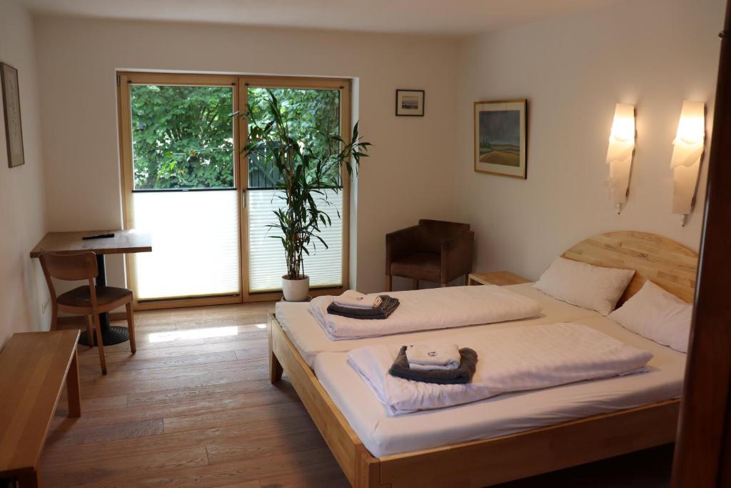 a bedroom with two beds and a large window at Hotel 11 Eulen in Uelzen