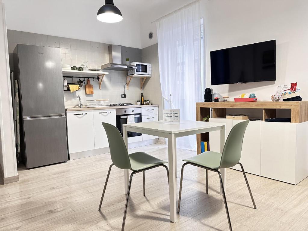 uma cozinha com uma mesa, 2 cadeiras e um frigorífico em Casa Bolina - Mini appartamento em Taranto