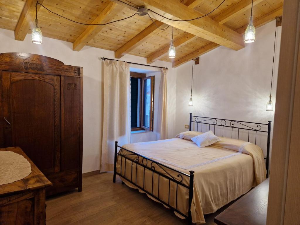 um quarto com uma cama e um tecto de madeira em CASA RO em Salaiola